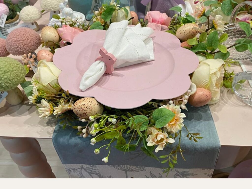 Guirlanda de ovos de Páscoa coloridos com sardas ao lado de uma estátua de coelho decorativo clássico.